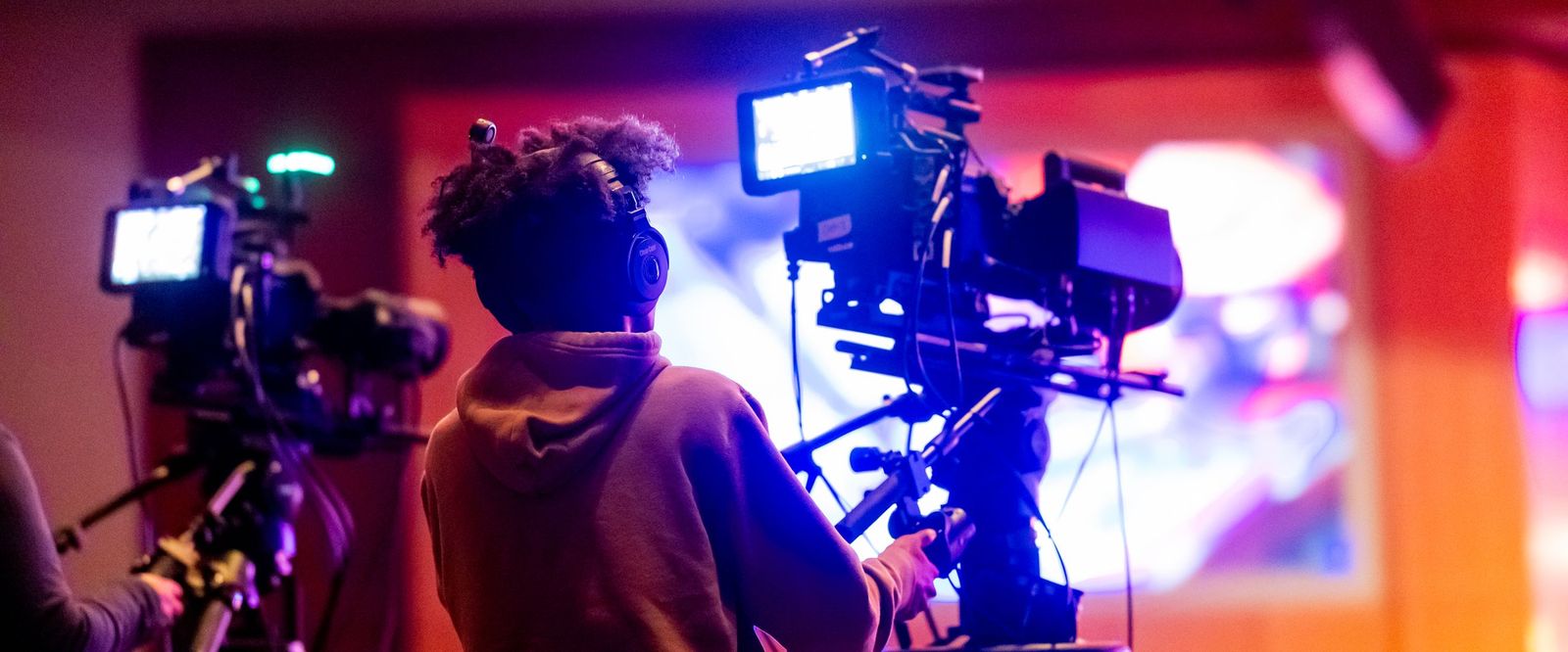 Camera operators filming in a brightly lit TV studio